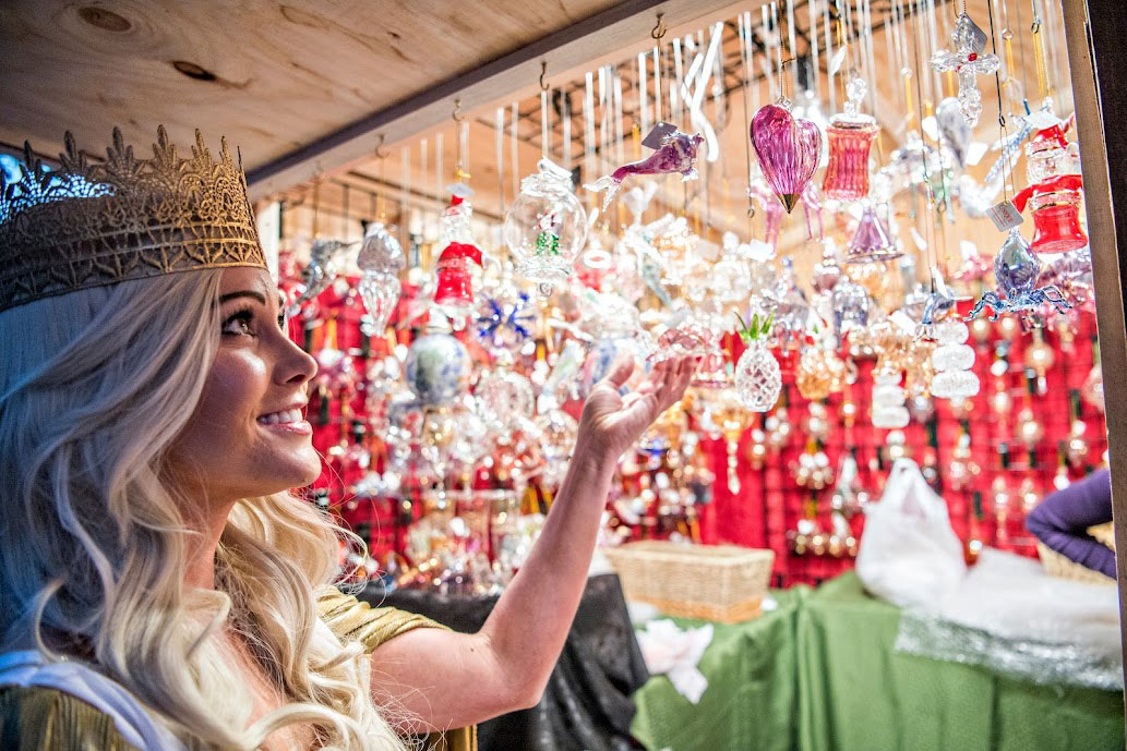 A woman admires glittering holiday ornaments at the Denver Christkindl Market
