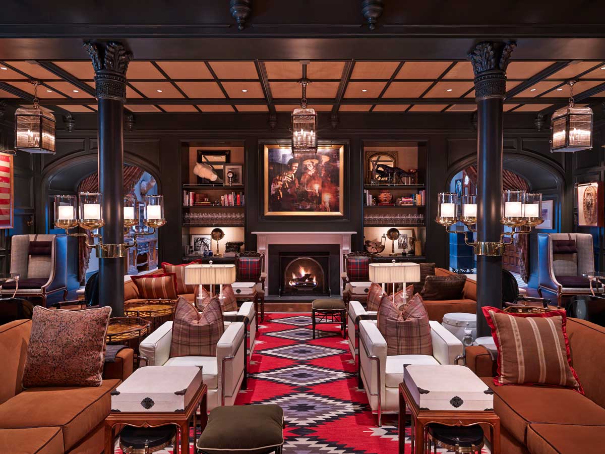 View of a hotel lobby with red geometric patterns on the carpet and several seating nooks