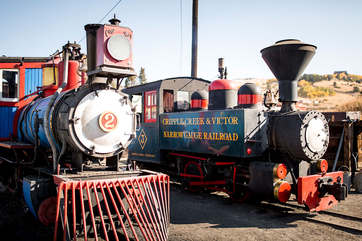 Two train steam engines parked outside