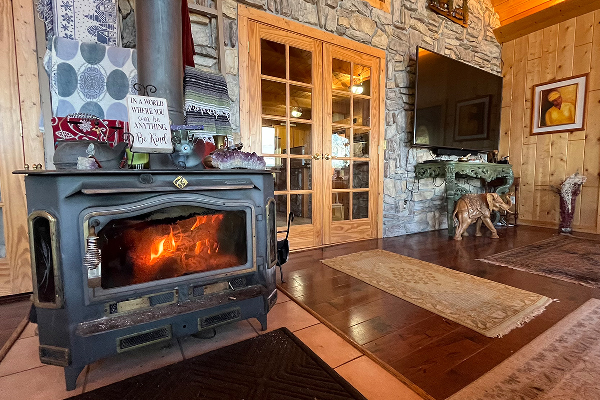 A stove fireplace contains a crackling, cozy fire at the Elkwood Manor Bed & Breakfast in Pagosa Springs, Colorado.