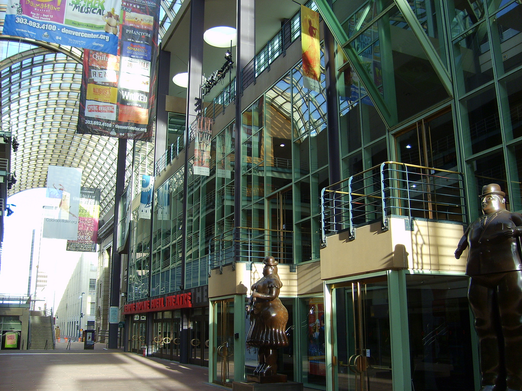 Exterior view of a glass-walled performing arts center in a downtown area